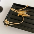 Nahaufnahme von goldenem Schmetterlings-Armreif mit Kristallblume auf schwarzem Tablett - Klein / Gold