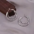 Silver double-layered hoop earrings with polished metal finish on grey fabric background - E-068---Platinum
