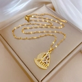 Nahaufnahme des goldenen Segelboot-Anhängers mit Zirkonia an einer Luxuskette - Gold Segelboot Anhänger Edelstahl Kette (E127)