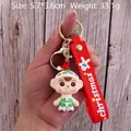 Cute Christmas elf PVC keychain with red strap and gold ring shown held by a hand - Christmas Baby