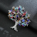 Macro shot of silver-plated tree of life brooch with vibrant colorful crystals on leather - Silver Tree of Life