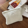 Nahaufnahme der cremefarbenen Tweed-Kosmetiktasche mit 'simple wish'-Label auf Holz - Creme