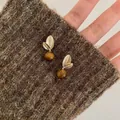 Chic gold leaf star earrings with brown tiger eye beads on warm knit background - Gold Leaf With Tiger Eye Pendant