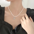 Elegant pearl necklace with a silver hollow heart cross pendant on a female model - 5902869302606 / Heart Cross Pearl Necklace (X0226) / Silver/Pearl White