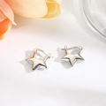 Detailaufnahme glänzender silberner Stern-Ohrringe auf einer minimalistischen weißen Fläche - Silber Stern
