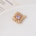 Vue détaillée du fermoir fleur en or avec pierre violette et zircons blancs étincelants - Camélia / Une rangée / Violet