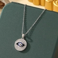 Silver Evil Eye necklace with white crystals and blue eye charm on green background - A11-Silver