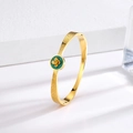 Close-up of vintage gold titanium steel bracelet with green floral clover details - Flower Green Shell Gold Bangle