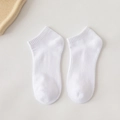 White low-cut cotton crew socks with ribbed cuffs shown on a beige textured background - Quarter / Cream