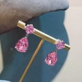 Macro detail of tear-drop pink gemstone earrings with silver base on a display stand - Pink