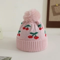 Close-up of pink knit hat featuring red cherry jacquard and fluffy faux fur pom-pom - 1-3 Years / Pink
