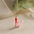 Détail macro d'un collier lettre W doré avec finition émaillée rose et rouge sur chaîne - Style-W