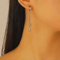 Orecchini a nappa lunga in acciaio al titanio argento con pendenti a goccia su modella - Orecchini (K1026) / Argento