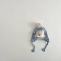 Détail du bonnet tricoté bébé montrant la texture douce du fil bleu et la broderie - 1-2 ans / Bleu