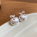Detail van appelvormige zilveren oorbellen met matte metaaltextuur en zirkoon steentjes - Zilver