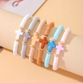 Dettaglio macro di un set di 6 braccialetti bohémien in argilla con ciondoli a croce colorati - Set da 6 / Multicolore