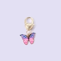 Pink and blue enamel butterfly keychain with golden heart-shaped clasp on purple background - Pink Blue Butterfly