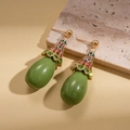 Detail of vintage teardrop resin earring with colorful crystals on a gold base - Green