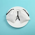 Two cream canvas drawstring jewelry pouches with black cords on a white plate - 7*9cm / White Cotton Black String