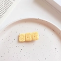 Détail d'une pince à cheveux fantaisie en forme de nouilles sur une assiette décorative - Nouilles Instantanées Carrées