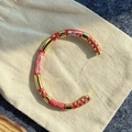 Detail of red and white marble texture on a gold plated minimalist open cuff bracelet - Red