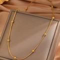Minimalist gold beaded snake chain necklace displayed on a luxury jewelry box cover - Bead Snake Chain / Gold