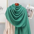 Detailed close-up of dark green linen scarf showing soft fabric texture and drape - Dark Green