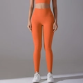 Detailed side view of high-waisted orange yoga pants with seamless athletic fabric - Orange
