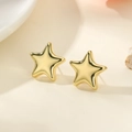 Macro view of 18k gold plated star stud earrings showing polished metal surface and thick edges - Gold