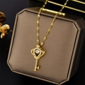 Elegant gold crown key necklace with a dancing central diamond on a luxury jewelry box - Gold