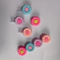Pastel flower-shaped spray bottle caps in pink and blue colors on white surface - Bulk Packaging / New Flower Plant