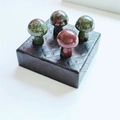 Polished mini mushroom stones in green and red jasper on a black textured base - Bloodstone