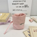 Detailansicht eines rosa karierten Stoffbeutels mit Kordelzug und gewebtem Markenlabel - Zartrosa Karo