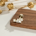 Clou d'oreille géométrique doré en zircon avec fermoir à vis plat sur un fond en bois - Café Clair-Or