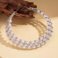 Detalle del collar de perlas de tres capas con diamantes sobre un fondo vintage - Plateado