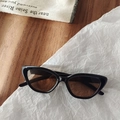 Detail of cat eye kids sunglasses with black frames and brown lenses on a wood background - Dark Brown