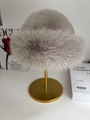 Winter plush faux fur bucket hat in silver grey displayed on a premium metal stand - Light Gray