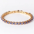 Bracelet chaîne dorée en cuivre avec zircons et breloques œil bleu sur fond blanc épuré - Bleu foncé