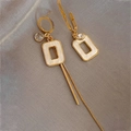 Detail of asymmetric gold tassel earrings with square inserts on silk fabric background - White Asymmetric Geometric Drop Earrings (Silver Earring Post)
