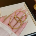 Eleganti orecchini a cerchio dorati con trama glitterata tenuti a mano su vassoio in velluto - Grandi Cerchi Scintillanti Oro (E0441 Oro)