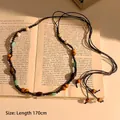 Detail of bohemian waist chain with wooden beads and conch on vintage books - Retro Woven (HN8722) / Dark Coffee