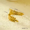 Macro shot of gold olive leaf ring with multi-layer structure on beige sand background - Double Layer Olive Leaf Wrap
