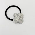 Black elastic hair tie featuring a silver textured metal flower charm detail - Shiny Silver - Clover