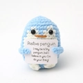 Close-up of a blue crochet positive penguin holding an encouraging message card - Light Blue Penguin P Card