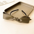 Detailed view of an olive green satin bow headband placed on a luxury metal tray decor - Brown