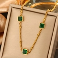 Golden titanium necklace with three square green gemstones on a silk display box - Vintage Green Square Gem