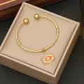 Detailed close-up of a gold-plated open bangle featuring an orange evil eye charm on a jewelry box - 6# Orange