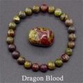 Macro detail of Dragon Blood stone beaded bracelet with red and green textured oval center - Dragon Blood Stone