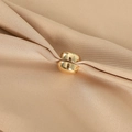 Elegant gold round magnetic hijab clips shown on soft beige textured fabric - Gold