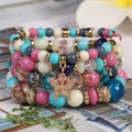 Mehrlagiges Boho-Perlenarmband mit bunten Kristallperlen und goldenem Schmetterlingsanhänger - Mehrfarbig